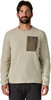 Ein Mann in einem beigen Pullover mit Reißverschlusstasche und Patagonia-Logo.