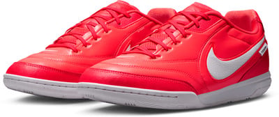 Pár červených futbalových topánok Nike s bielym logom a podrážkou. Pár červených futbalových topánok Nike s bielym logom a podrážkou.