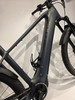 Rahmendetail eines dunkelgrauen E-Bikes mit buntem Logo und Flaschenhalter.