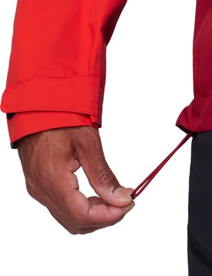 Eine Hand passt den roten Kordelzug an einer Jacke an. Eine Hand passt den roten Kordelzug an einer Jacke an.