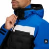 Ein Mann schließt eine blaue Jacke mit schwarzen und weißen Streifen.