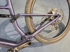 Der hintere Teil eines violetten Mountainbikes mit Dämpfer und Antrieb.