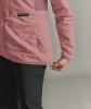 Eine rosafarbene Steppjacke mit schwarzer Hose und ORTOVOX-Logo.