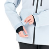 Eine Frau richtet den Ärmel einer Jacke mit DRYPLAY-Logo vor weißem Hintergrund aus.