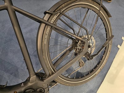 Hinterrad eines schwarzen E-Bikes mit Schutzblech und Gepäckträger. Hinterrad eines schwarzen E-Bikes mit Schutzblech und Gepäckträger.