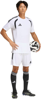 Ein Mann im weißen Fußballtrikot und Shorts mit Ball. Ein Mann im weißen Fußballtrikot und Shorts mit Ball.