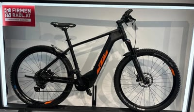 Schwarzes KTM E-Bike mit orangefarbenen Akzenten und Schriftzug. Schwarzes KTM E-Bike mit orangefarbenen Akzenten und Schriftzug.