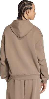 Rückansicht eines Mannes mit Zöpfen in einem braunen Kapuzenpullover und Jogginghose. Rückansicht eines Mannes mit Zöpfen in einem braunen Kapuzenpullover und Jogginghose.