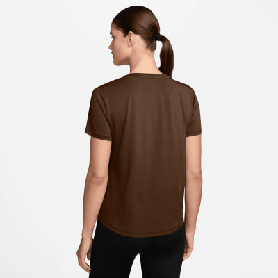 Eine Frau in einem braunen T-Shirt und schwarzer Leggings von hinten gesehen. Eine Frau in einem braunen T-Shirt und schwarzer Leggings von hinten gesehen.