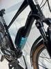 Schwarzes E-Bike mit farbiger Batterie und braunen Reifen.
