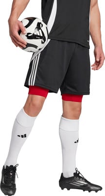 Ein Fußballer hält einen Ball, trägt schwarze Shorts, rote Unterhosen und weiße Socken. Ein Fußballer hält einen Ball, trägt schwarze Shorts, rote Unterhosen und weiße Socken.