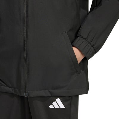 Detail einer Jacke mit Tasche und Adidas-Logo auf der Hose. Detail einer Jacke mit Tasche und Adidas-Logo auf der Hose.