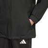 Detail einer Jacke mit Tasche und Adidas-Logo auf der Hose.