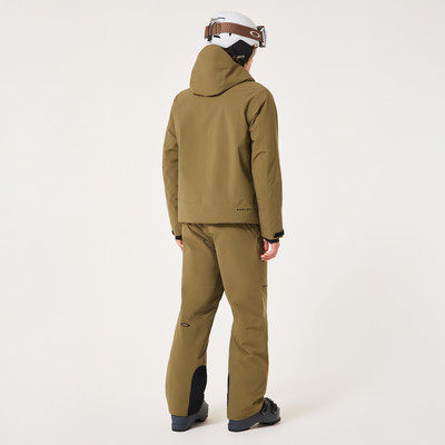 Rückansicht eines Skifahrers in brauner Jacke und Hose mit Helm.