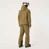 Rückansicht eines Skifahrers in brauner Jacke und Hose mit Helm.