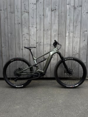 Ein E-Mountainbike steht vor einer Holzwand. Ein E-Mountainbike steht vor einer Holzwand.