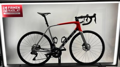 Ein silber-rotes Trek Rennrad mit Schriftzug auf dem Rahmen und Logo auf rotem Schild. Ein silber-rotes Trek Rennrad mit Schriftzug auf dem Rahmen und Logo auf rotem Schild.