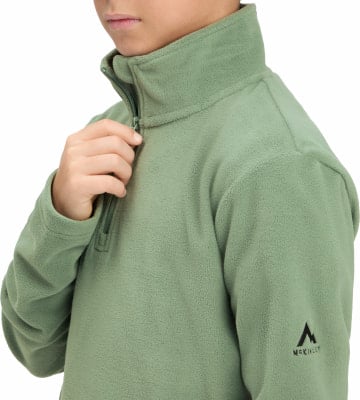 Ein Kind schließt einen grünen Fleece-Pullover mit Stehkragen. Ein Kind schließt einen grünen Fleece-Pullover mit Stehkragen.