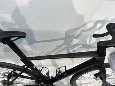 Ein schwarzes Rennrad mit schmalem Lenker und Schattenreflexion an der Wand. Ein schwarzes Rennrad mit schmalem Lenker und Schattenreflexion an der Wand.