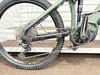 Grünes Mountain-E-Bike mit sichtbarem Schaltwerk und Kassette.