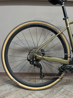Ein goldenes Fahrrad mit beigen Reifen und schwarzen Felgen vor grauem Hintergrund. Ein goldenes Fahrrad mit beigen Reifen und schwarzen Felgen vor grauem Hintergrund.