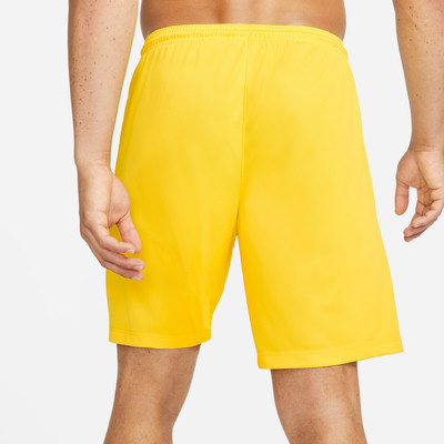 Ein Mann trägt gelbe Shorts von der Seite, eine Hand in der Tasche. Ein Mann trägt gelbe Shorts von der Seite, eine Hand in der Tasche.