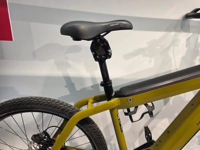 Detail des Sattels und der Sattelstütze eines gelben E-Bikes von der Seite. Detail des Sattels und der Sattelstütze eines gelben E-Bikes von der Seite.