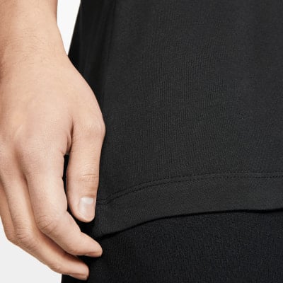 Detail einer Hand und eines schwarzen T-Shirts mit genähtem Saum. Detail einer Hand und eines schwarzen T-Shirts mit genähtem Saum.