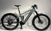 Ein graues Cube E-Bike mit Federung und Schutzblechen steht vor weißem Hintergrund.