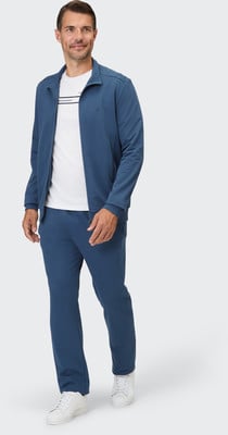 Ein Mann im blauen Trainingsanzug und weißem T-Shirt mit Streifen. Ein Mann im blauen Trainingsanzug und weißem T-Shirt mit Streifen.