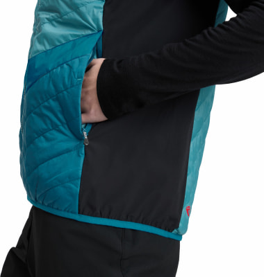 Mann in einer Steppweste mit schwarzem Stoff und blauer Kapuze, Hand in der Tasche. Mann in einer Steppweste mit schwarzem Stoff und blauer Kapuze, Hand in der Tasche.