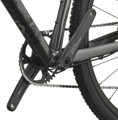 Detail des Shimano CUES Fahrrad-Kettenblatts und der Kurbel auf dunklem Rahmen. Detail des Shimano CUES Fahrrad-Kettenblatts und der Kurbel auf dunklem Rahmen.