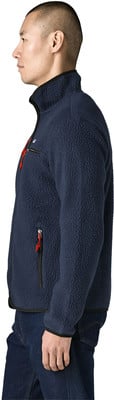 Mann in dunkelblauem Fleece-Pullover mit rotem Detail, Profil.