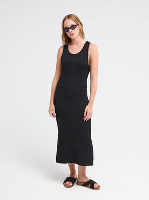 Eine Frau in schwarzem ärmellosem Kleid und Sonnenbrille posiert vor weißem Hintergrund. Eine Frau in schwarzem ärmellosem Kleid und Sonnenbrille posiert vor weißem Hintergrund.