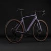 Lila Gravelbike mit braunen Reifen und schwarzem Rahmen.