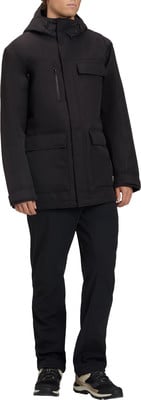 Mann in schwarzer Winterjacke mit Kapuze, schwarzer Hose und Schuhen. Mann in schwarzer Winterjacke mit Kapuze, schwarzer Hose und Schuhen.