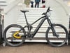 Schwarzes E-Bike mit Federung auf einer Treppe, gelbe Rahmendetails.