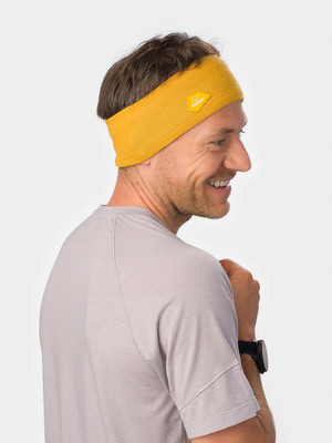 Ein Mann mit einem senfgelben Stirnband und grauem T-Shirt.