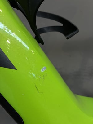 Am grünen Fahrradrahmen befindet sich ein Kratzer mit mehreren Schrammen. Am grünen Fahrradrahmen befindet sich ein Kratzer mit mehreren Schrammen.