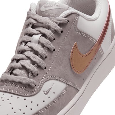 Szürke Nike cipő részletes képe arany pipával és rózsaszín csíkkal. Szürke Nike cipő részletes képe arany pipával és rózsaszín csíkkal.