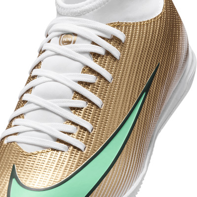 Goldener Fußballschuh mit weißen Schnürsenkeln und grünem Nike-Logo.