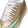 Goldener Fußballschuh mit weißen Schnürsenkeln und grünem Nike-Logo.