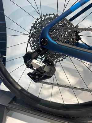 SRAM APEX X Schaltwerk an einem blauen Fahrradrahmen. SRAM APEX X Schaltwerk an einem blauen Fahrradrahmen.