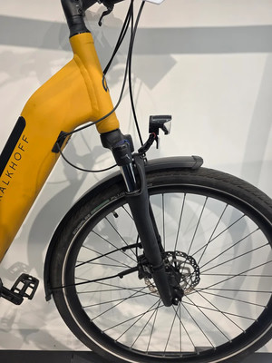 Ein gelbes E-Bike mit Vorderlicht und Schutzblech. Ein gelbes E-Bike mit Vorderlicht und Schutzblech.