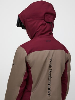 Rückansicht einer Peak Performance Jacke mit Kapuze und Logo. Rückansicht einer Peak Performance Jacke mit Kapuze und Logo.