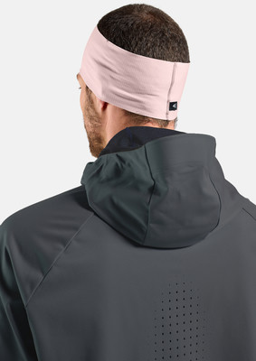 Mann mit rosa Stirnband und dunkler Kapuzenjacke.