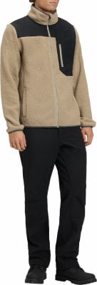 Mann in einem beige Fleecejacke mit schwarzen Einsätzen und schwarzer Hose. Mann in einem beige Fleecejacke mit schwarzen Einsätzen und schwarzer Hose.