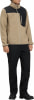 Mann in einem beige Fleecejacke mit schwarzen Einsätzen und schwarzer Hose.