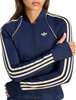 Dunkelblaue Adidas Jacke für Damen mit cremefarbenen Streifen und Logo auf der Brust.