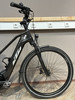 Schwarzes KTM E-Bike mit Vorderradgabel und Rad auf Holzboden.